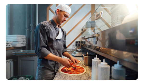 Chef cocinando una pizza en cocina