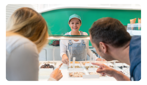 Comensales eligiiendo sabor de helado en mostrador