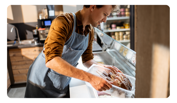 Gerente de heladeria en vitrina de helados