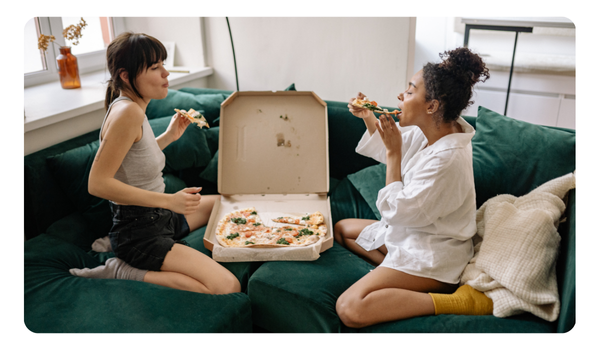 amigas compartiendo una pizza mientras charlan