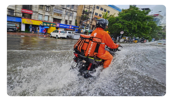 repartidor de delivery app en moto en lluvia