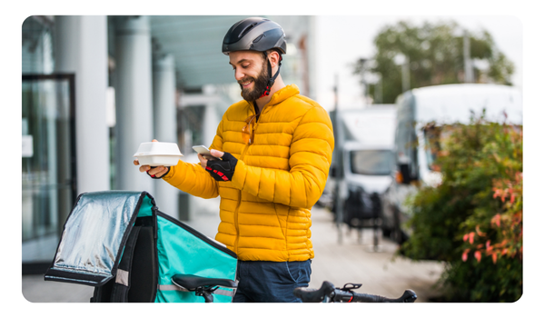 repartidor revisando app en bicicleta